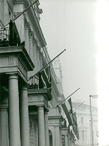 Vintage fotografija zastava ujedinjene kraljevstva i druge zastave prikazana je pola jarbola izvan zgrade kao simbol žalosti za smrt